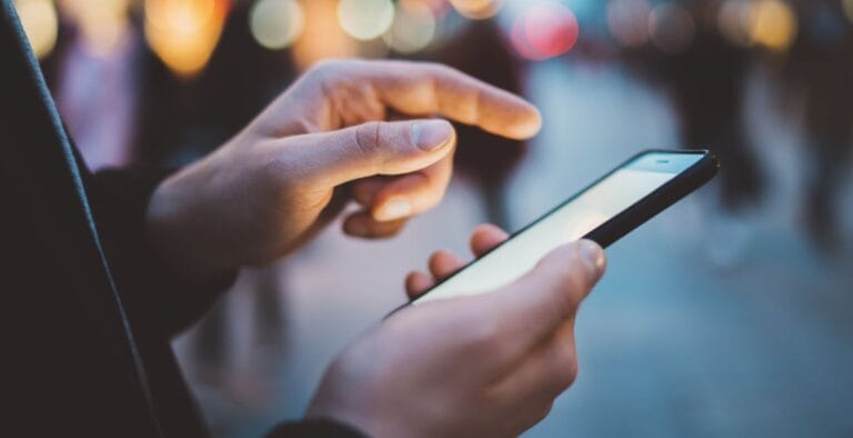 Mand bruger sin mobiltelefon udenfor