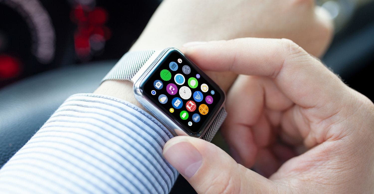 Mand i skjorte bruger smartwatch i bil