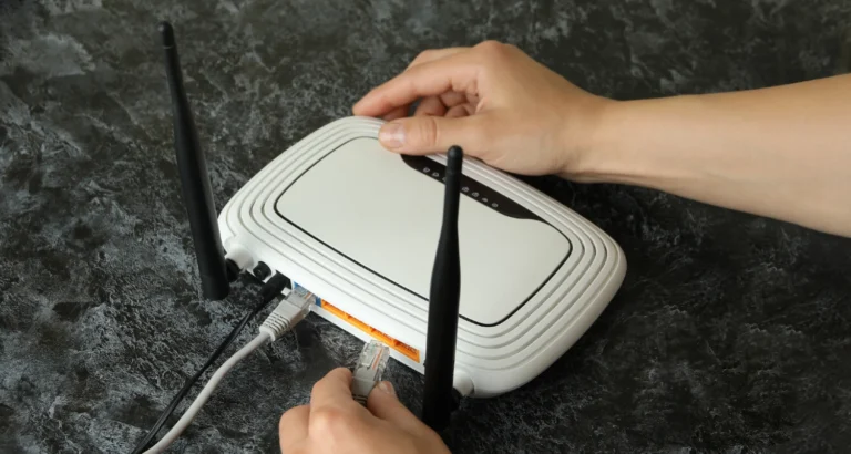 Mand opsætter bredbåndsrouter med netværkskabler