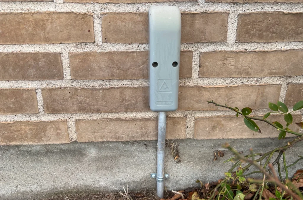 Grå udvendig fiberboks monteret på husmur