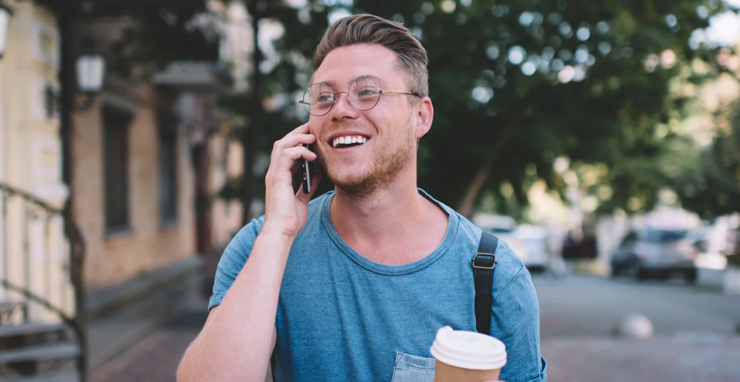 Mand går på gaden og taler i mobiltelefon